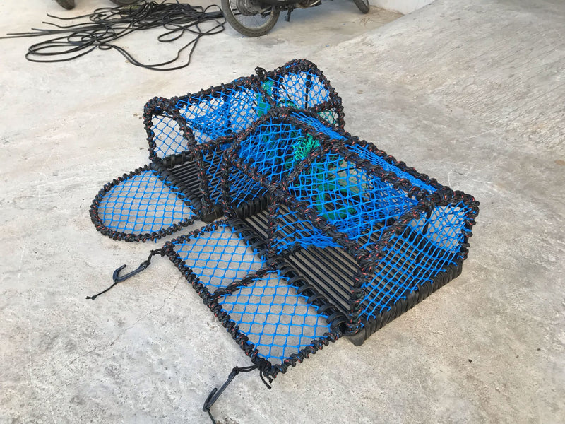 Blue and black lobster creel/pot on a concrete surface
