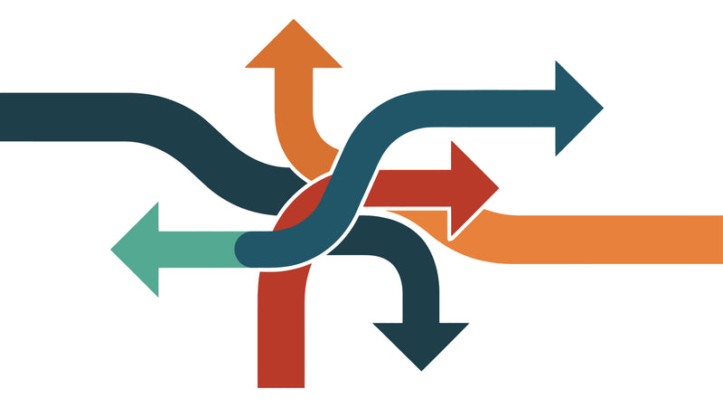 A minimalist vector graphic of four intersecting arrows in dark teal, orange, red, and light green on a solid white background.
