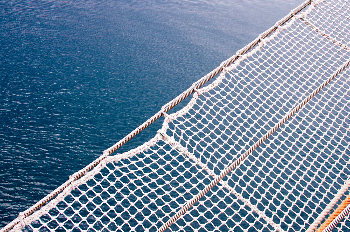 Close-up of a white safety net against a blue water background